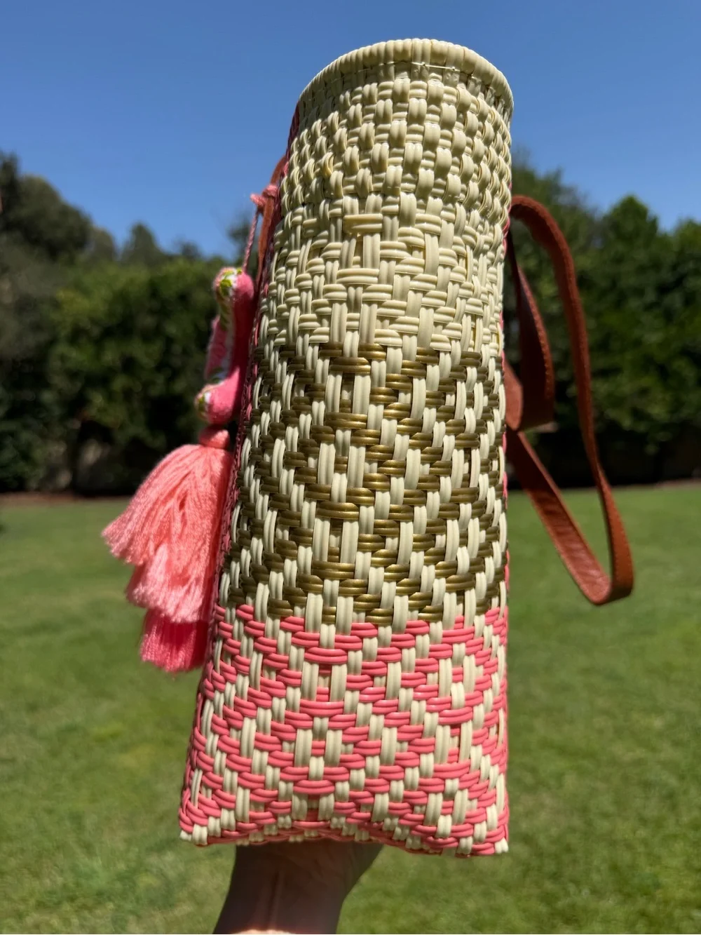 Woven Straw Tote Bag with Brown Leather Handles and Pink Tassel Accent